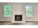 Living room fireplace with flanking windows looking out to a lush backyard at 4110 Ridgebrook Bnd, Cumming, GA 30028