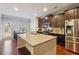 Bright kitchen featuring a center island, stainless steel appliances, and dark cabinetry at 981 Sonoma Dr, Lawrenceville, GA 30045