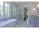 Bright bathroom offers a soaking tub and separate glass enclosed shower with marble tile at 986 Carl Sanders Dr, Acworth, GA 30101