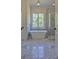 Bright bathroom offers a soaking tub under a window with a separate glass enclosed shower at 986 Carl Sanders Dr, Acworth, GA 30101