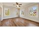 Bright bedroom with hardwood floors, fan, and three large windows overlooking yard at 1865 Butlers Ln, Decatur, GA 30033