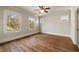 An empty bedroom with beautiful hardwood floors and windows looking out onto a tree-lined street at 1865 Butlers Ln, Decatur, GA 30033