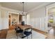 Open dining room with wainscoting, wood floors, modern lighting and seamless access to other rooms at 1865 Butlers Ln, Decatur, GA 30033