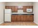 A kitchenette with wood cabinets, laminate counters, a white refrigerator, and a microwave at 1865 Butlers Ln, Decatur, GA 30033