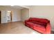 A living room with a red sofa, wood floors, and an entrance to a bathroom at 1865 Butlers Ln, Decatur, GA 30033