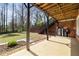 Covered patio showcasing wood ceiling, staircase, and exterior utilities against lush greenery at 1865 Butlers Ln, Decatur, GA 30033