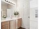 Well-lit bathroom with a double sink vanity, laminate countertop, cabinets, and a large mirror with decorative lighting at 2939 Greyhawk Ln, Cumming, GA 30040