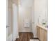 Well-lit bathroom with a shower-tub combo, wood-look floors, and a bright white cabinet vanity at 2939 Greyhawk Ln, Cumming, GA 30040