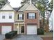 Charming townhome with a brick and siding facade, featuring a one-car garage and manicured landscaping at 2939 Greyhawk Ln, Cumming, GA 30040