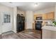 Kitchen with stainless steel sink, gas stove, wooden cabinets, and black refrigerator at 2939 Greyhawk Ln, Cumming, GA 30040