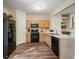 Kitchen with stainless steel sink, wooden cabinets, gas stove, and black appliances at 2939 Greyhawk Ln, Cumming, GA 30040