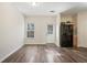 Living room with hardwood floors, neutral paint, white door, and black refrigerator at 2939 Greyhawk Ln, Cumming, GA 30040