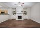 The spacious living room features a fireplace with built-in shelving, and wood floors at 2939 Greyhawk Ln, Cumming, GA 30040