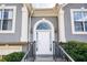 Close up of the front door with an arched window, decorative columns and black railings at 4170 Hopkins Bluff Way, Duluth, GA 30096