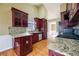 Kitchen featuring granite counters, stainless steel appliances, cherry cabinets and hardwood floors at 4170 Hopkins Bluff Way, Duluth, GA 30096