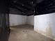 Unfinished basement with concrete floor, walls with peeling white paint, and black plastic on ceiling at 675 Paper Creek Dr, Lawrenceville, GA 30046