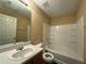 This bathroom is well-lit and clean, with a tub-shower, wooden vanity, and tile floors at 675 Paper Creek Dr, Lawrenceville, GA 30046