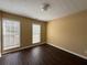 Bright bedroom featuring dark floors and light-colored walls, with two windows providing ample natural light at 675 Paper Creek Dr, Lawrenceville, GA 30046