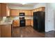 Well-equipped kitchen features wooden cabinets, black appliances, and granite countertops at 1109 Willow Crest Way, Austell, GA 30168