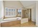 Luxurious main bathroom featuring a soaking tub, tiled shower with glass surround, and tile floors at 3023 Lawson Dr, Marietta, GA 30064