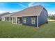 Wide backyard showcases a covered patio, lush green lawn, and blue-paneled house exterior at 53 Colonial Ter, Villa Rica, GA 30180