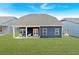 View of the backyard of a home with grass, a small porch, and outdoor seating at 53 Colonial Ter, Villa Rica, GA 30180
