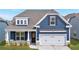 Charming blue home featuring stone accents, a two-car garage, and a welcoming front porch at 53 Colonial Ter, Villa Rica, GA 30180