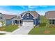 Attractive blue home exterior with a well-kept lawn, a two-car garage and a clean driveway at 53 Colonial Ter, Villa Rica, GA 30180