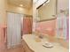 This bathroom has pastel pink tiling, a glass shower door, and classic fixtures at 643 Longstreet Dr, Marietta, GA 30064