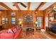 Cozy living room featuring wood paneling, beamed ceilings, brick fireplace, and custom built-ins at 643 Longstreet Dr, Marietta, GA 30064