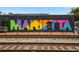 Vibrant mural art in Marietta, GA, featuring the city's name in bold colors, visible next to train tracks at 643 Longstreet Dr, Marietta, GA 30064