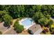 Aerial view of the community pool and clubhouse surrounded by mature trees and parking area at 1203 Bonshaw Trl, Marietta, GA 30064