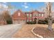 Two-story brick home with two-car garage and meticulously landscaped front yard at 1203 Bonshaw Trl, Marietta, GA 30064