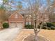 Elegant brick home with an arched entryway, two-car garage and mature trees at 1203 Bonshaw Trl, Marietta, GA 30064