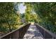 Walking bridge across a manicured lawn and surrounded by lush trees and plants at 1203 Bonshaw Trl, Marietta, GA 30064