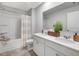 Bright bathroom with double sinks, white cabinets, and a shower-tub combination at 218 Highgrove Way, Dallas, GA 30157