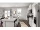 Bright kitchen features stainless appliances, stone countertops, eat-in island, and wood floors at 218 Highgrove Way, Dallas, GA 30157