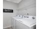 Functional laundry room with modern washer and dryer units and ample shelving at 218 Highgrove Way, Dallas, GA 30157
