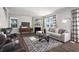 A spacious living room showcases cozy seating, neutral colors, and a geometric patterned rug at 218 Highgrove Way, Dallas, GA 30157