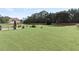 Spacious backyard with lush green grass, mature trees, and a brick patio at 50 Cannonade Ct, Covington, GA 30016
