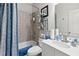 Bathroom featuring shower over tub, white vanity, and decorative blue accents at 50 Cannonade Ct, Covington, GA 30016