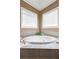 Bright bathroom showcasing large soaking tub with tiled surround and natural light at 50 Cannonade Ct, Covington, GA 30016