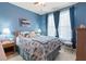 Blue bedroom featuring bright natural light from large window with decorative curtains and bedding at 50 Cannonade Ct, Covington, GA 30016