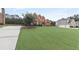 Well-manicured lawn leads up to a red brick two-story house with green shutters and a driveway at 50 Cannonade Ct, Covington, GA 30016