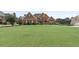 Well-manicured lawn leads up to a red brick two-story house with green shutters and a driveway at 50 Cannonade Ct, Covington, GA 30016