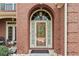 Elegant entryway featuring a brick archway, decorative glass door, and stylish outdoor lighting at 50 Cannonade Ct, Covington, GA 30016