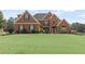 Charming brick home with a manicured lawn, lush landscaping, and classic architectural details at 50 Cannonade Ct, Covington, GA 30016