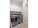 Efficient laundry room featuring modern washer/dryer, white cabinets, and tile flooring at 50 Cannonade Ct, Covington, GA 30016