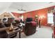 Spacious living room with red accent wall, comfortable sofas, and a ceiling fan at 50 Cannonade Ct, Covington, GA 30016
