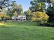 Expansive backyard with manicured lawn, mature trees, fenced-in pasture, and the house in the background at 77 Russell Rd, Lawrenceville, GA 30043
